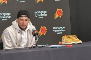 布克赛后拿着库里亲穿的Book1出席采访 上有后者的签名